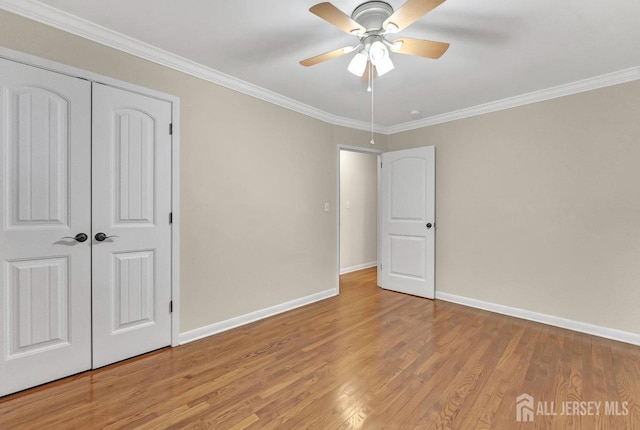 unfurnished bedroom with ornamental molding, light wood-type flooring, and baseboards