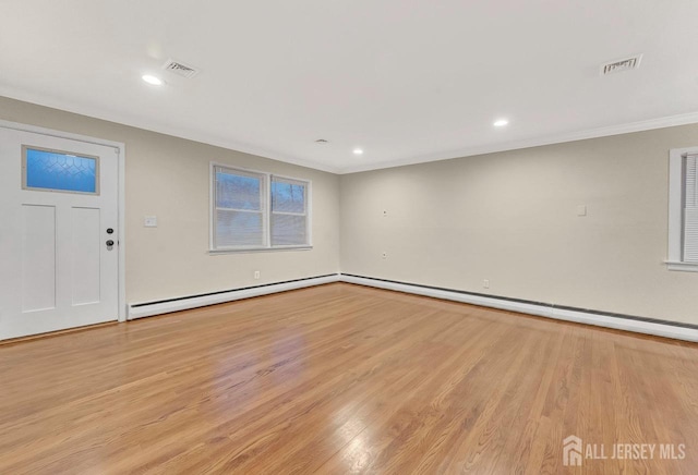 interior space featuring a baseboard heating unit, light wood finished floors, visible vents, and recessed lighting