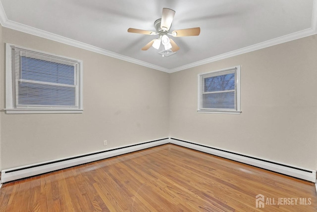 spare room featuring ceiling fan, a baseboard heating unit, light wood finished floors, and crown molding