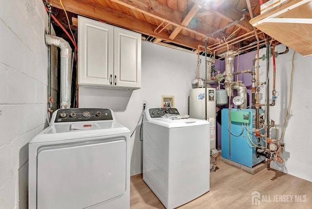 clothes washing area featuring cabinet space, light wood-style flooring, separate washer and dryer, and gas water heater