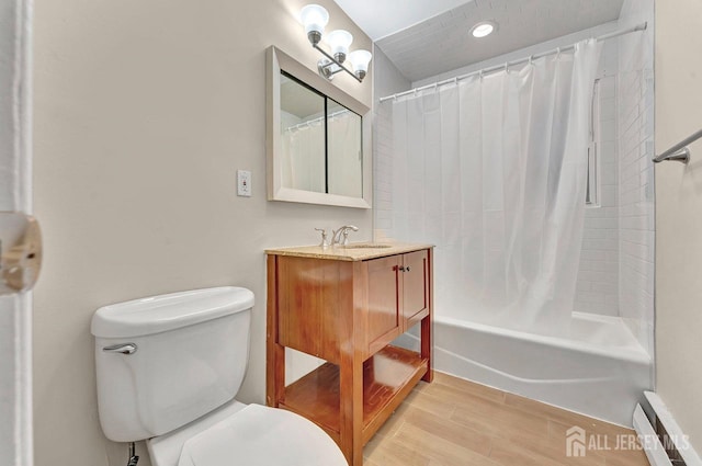 bathroom featuring toilet, shower / bathtub combination with curtain, wood finished floors, and vanity