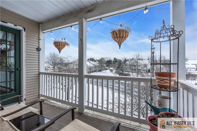 view of snow covered back of property