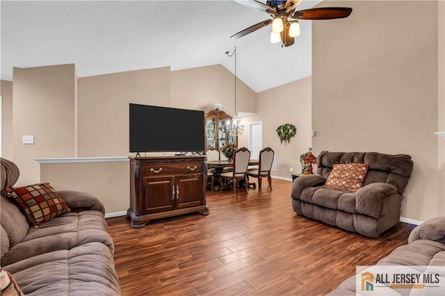 living area featuring dark wood-style floors, high vaulted ceiling, baseboards, and ceiling fan with notable chandelier