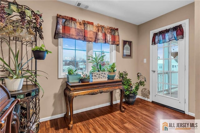 entryway with visible vents, baseboards, and wood finished floors