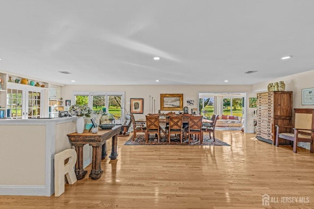 dining space featuring french doors and light hardwood / wood-style floors