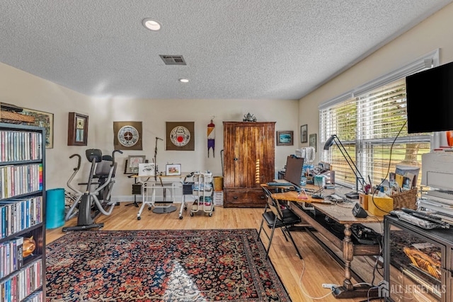 office space featuring a textured ceiling and light hardwood / wood-style floors