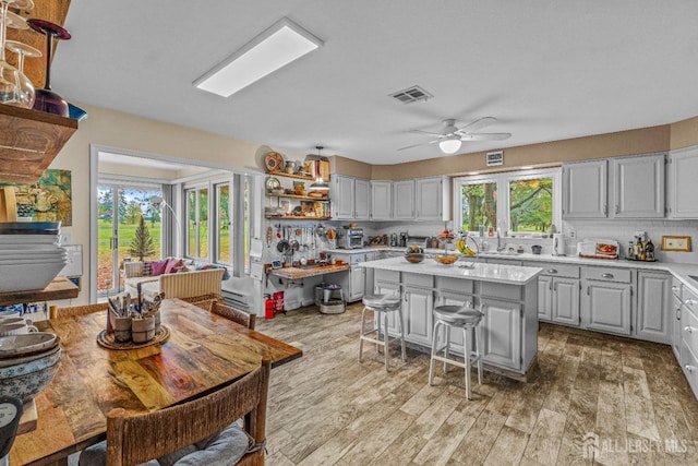 kitchen featuring a center island, light wood-type flooring, a breakfast bar area, and a wealth of natural light