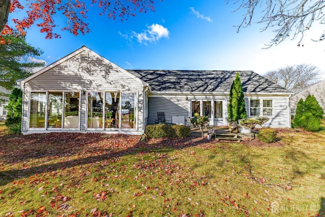 back of house featuring a yard and a sunroom