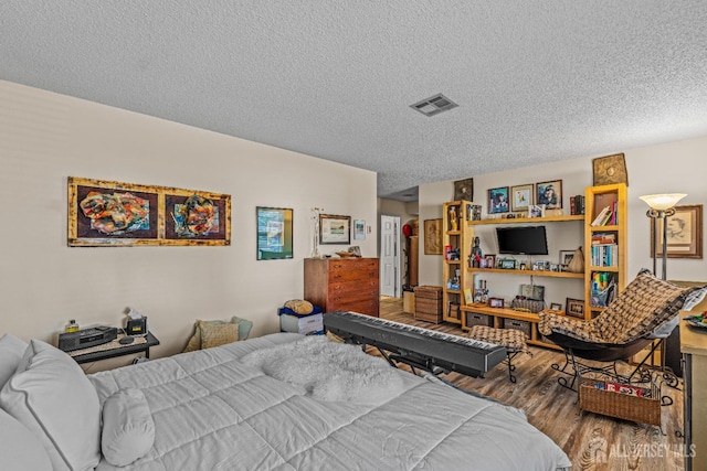 bedroom featuring wood-type flooring and a textured ceiling