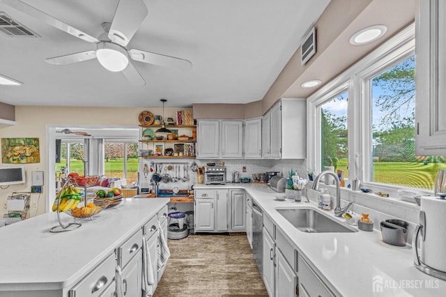 kitchen with sink, a center island, white cabinets, and ceiling fan