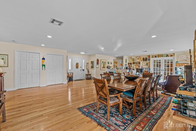 dining room with french doors and light hardwood / wood-style flooring