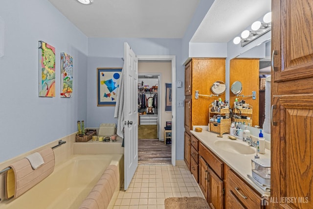 bathroom featuring tile patterned floors, a bath, and vanity