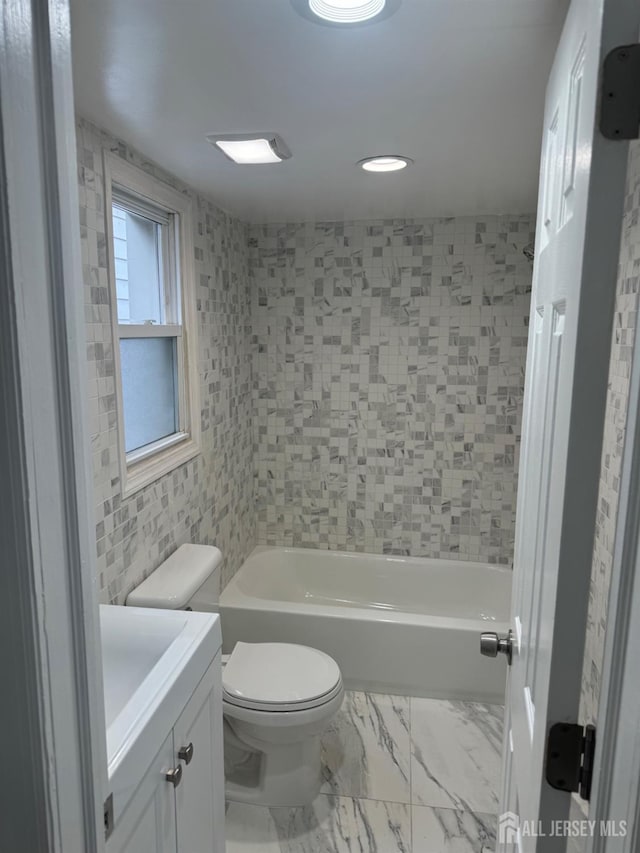 full bathroom with vanity, tiled shower / bath combo, and toilet