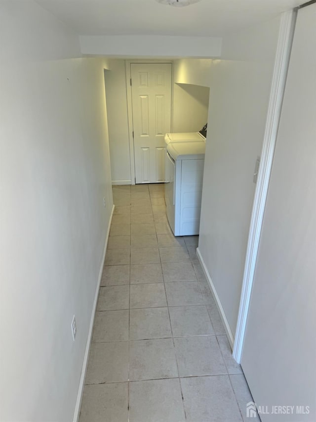 corridor featuring washer and clothes dryer and light tile patterned floors