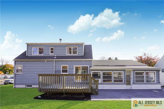 back of property with a wooden deck, a patio area, and a lawn