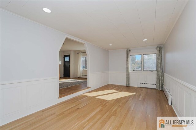 unfurnished room featuring light hardwood / wood-style floors and baseboard heating