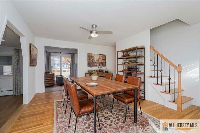 dining area with baseboard heating, ceiling fan, and light wood-type flooring