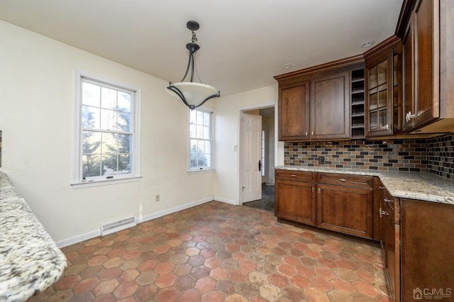 kitchen with backsplash, hanging light fixtures, baseboards, and visible vents