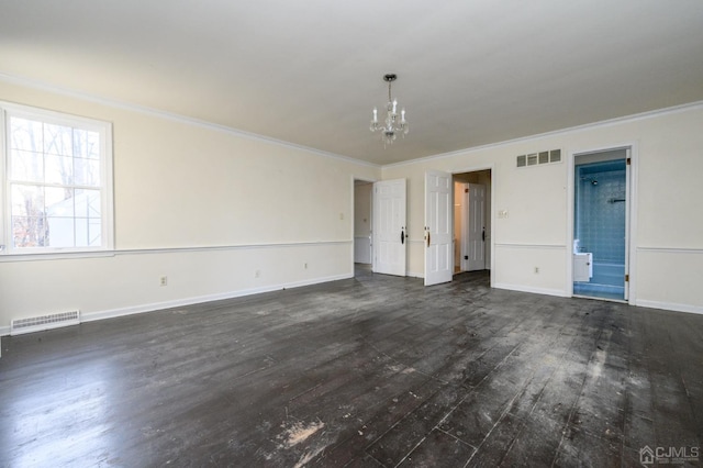 empty room featuring crown molding, a notable chandelier, visible vents, and dark wood finished floors