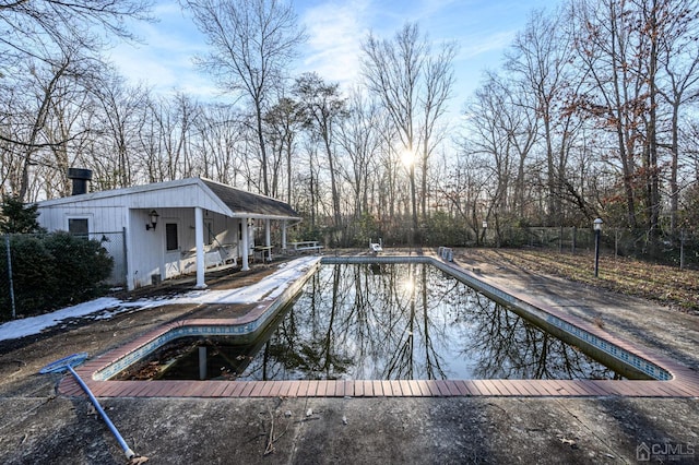 outdoor pool with fence and a patio area