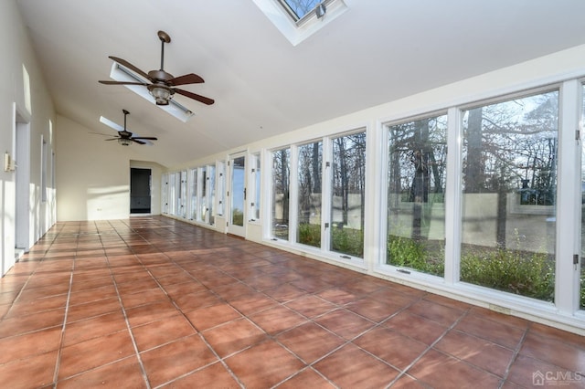 unfurnished sunroom featuring tile patterned flooring, high vaulted ceiling, and a skylight