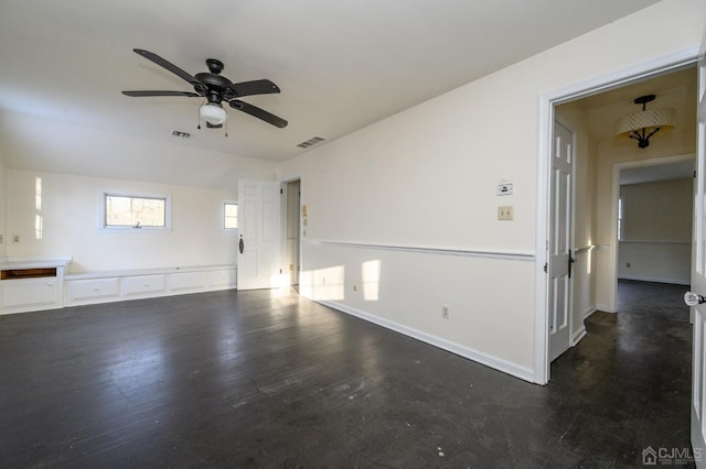 spare room with baseboards, a ceiling fan, wood finished floors, and visible vents