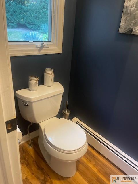 bathroom with toilet, wood finished floors, and a baseboard radiator