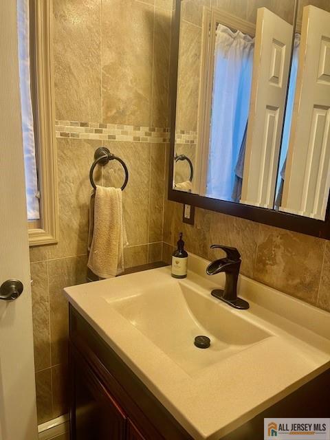 bathroom with tile walls and vanity