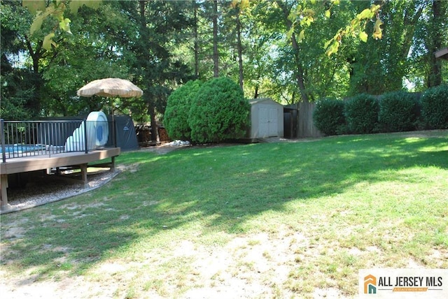 view of yard featuring a wooden deck, a storage shed, and an outdoor structure