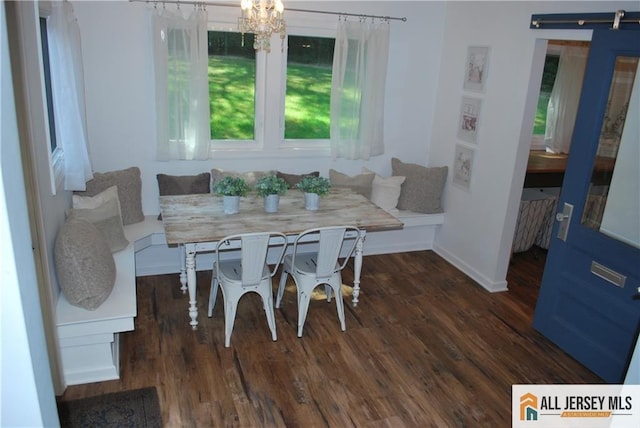 dining area featuring baseboards, breakfast area, a barn door, and wood finished floors