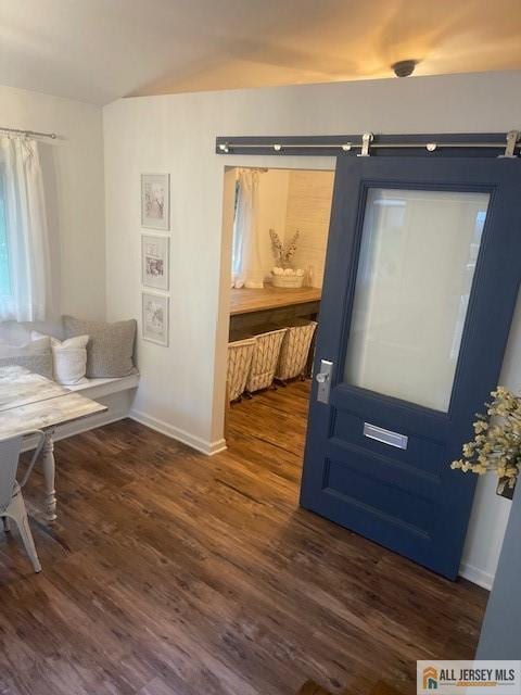 entryway with a barn door, baseboards, and dark wood-style flooring