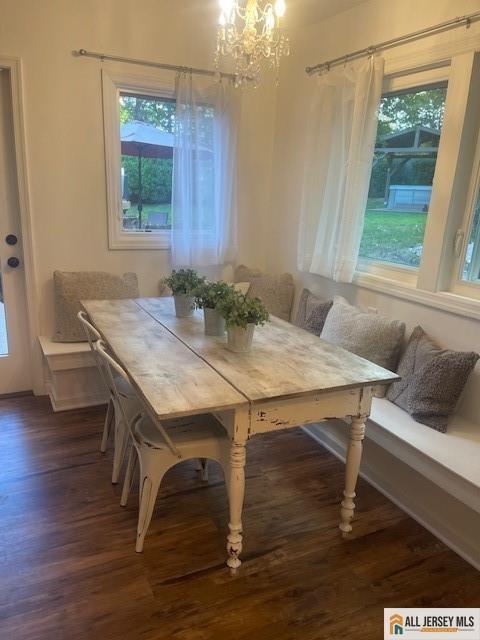 dining room featuring a chandelier, wood finished floors, breakfast area, and a healthy amount of sunlight