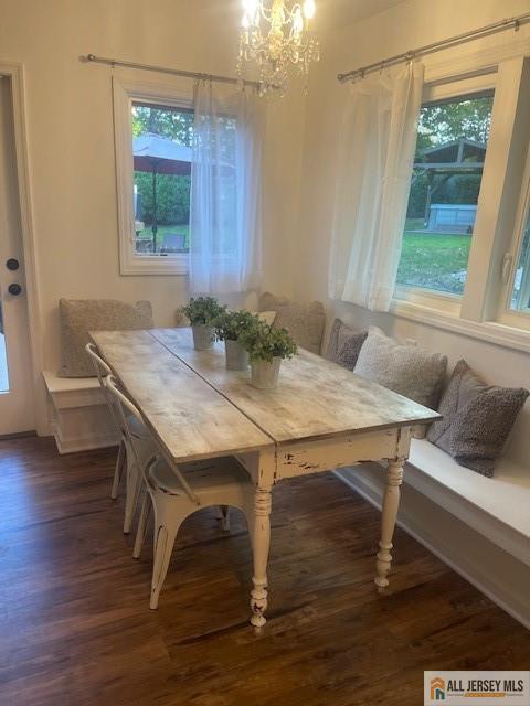 dining space featuring a chandelier, wood finished floors, breakfast area, and a healthy amount of sunlight