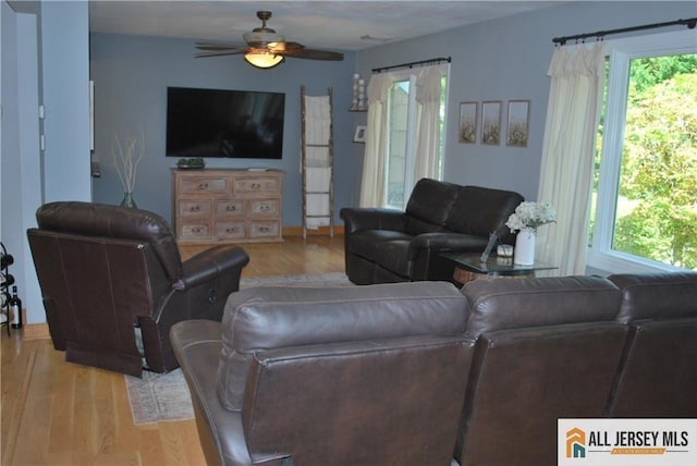 living room featuring a wealth of natural light, light wood-style floors, and a ceiling fan