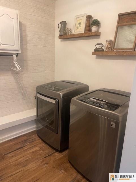 laundry area with dark wood-style floors, laundry area, washing machine and dryer, and electric panel