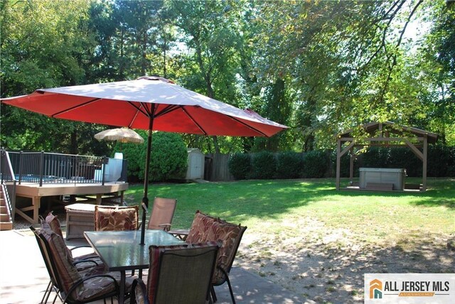 view of patio / terrace with a deck, outdoor dining space, a gazebo, a storage shed, and an outdoor structure