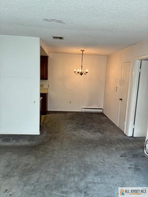 unfurnished room with baseboard heating, a notable chandelier, a textured ceiling, and dark colored carpet