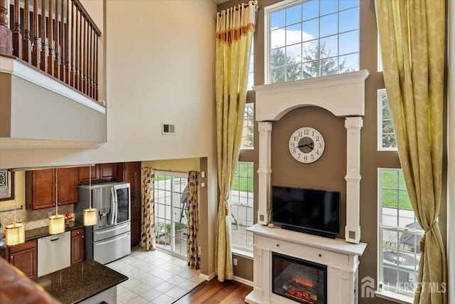 2420 Canterbury Ln, North Brunswick, NJ 08902 - living room with a high ceiling, decorative columns, and a glass covered fireplace