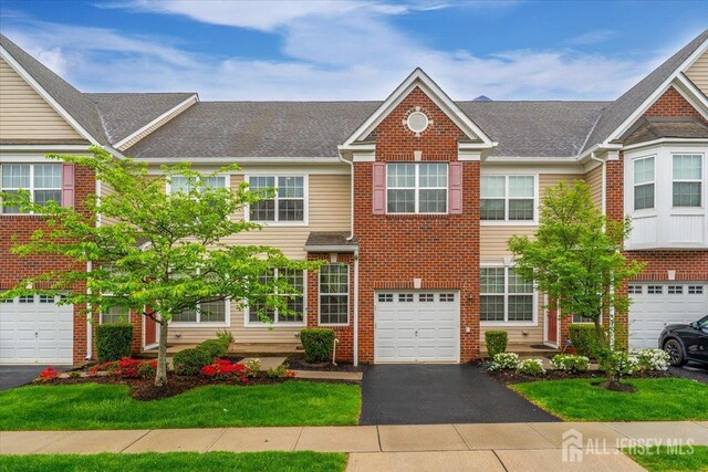 2420 Canterbury Ln, North Brunswick, NJ 08902 - townhome / multi-family property featuring driveway, a garage, and brick siding