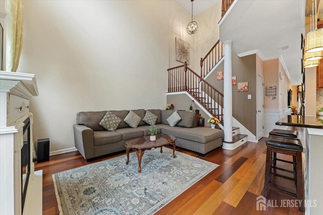2420 Canterbury Ln, North Brunswick, NJ 08902 - living area featuring wood finished floors, a fireplace, stairs, a towering ceiling, and ornamental molding