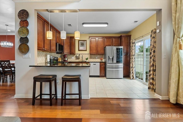 2420 Canterbury Ln, North Brunswick, NJ 08902 - kitchen featuring stainless steel appliances, dark countertops, light wood finished floors, and backsplash