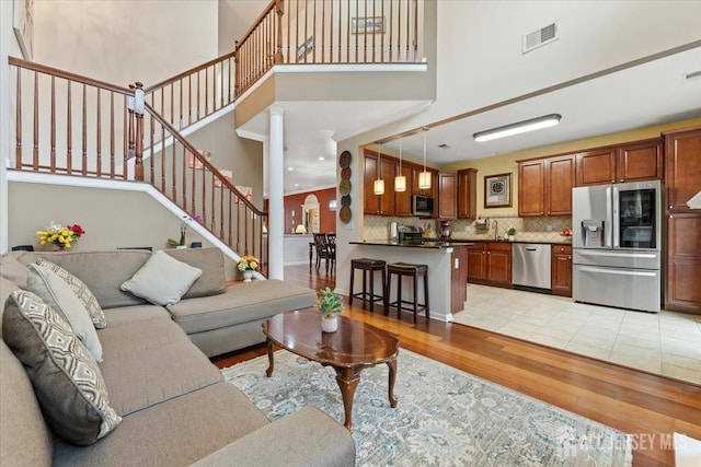 2420 Canterbury Ln, North Brunswick, NJ 08902 - living area with light wood finished floors, stairway, and a towering ceiling