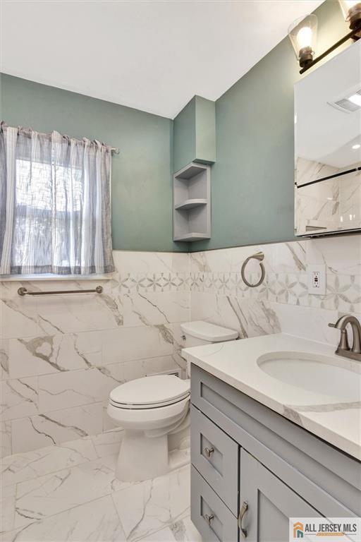 27 Laurel St, South Amboy, NJ 08879 - bathroom featuring tile walls, vanity, and marble finish floors