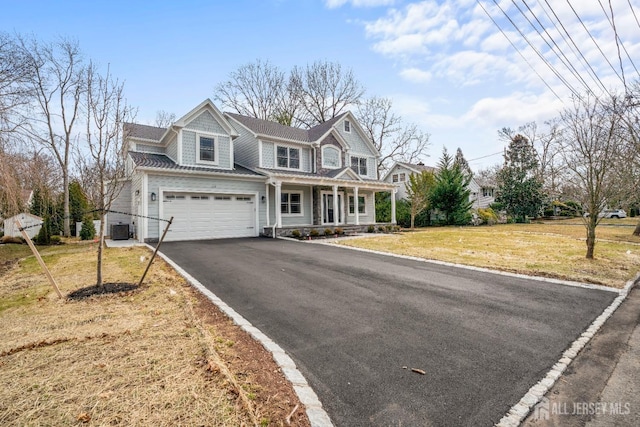 view of front facade with a front lawn, driveway, and covered porch