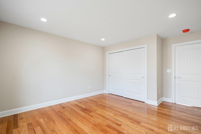 unfurnished bedroom featuring recessed lighting, light wood-style floors, and baseboards