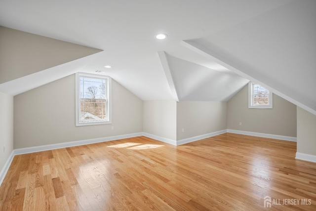 additional living space featuring recessed lighting, baseboards, lofted ceiling, and light wood-type flooring