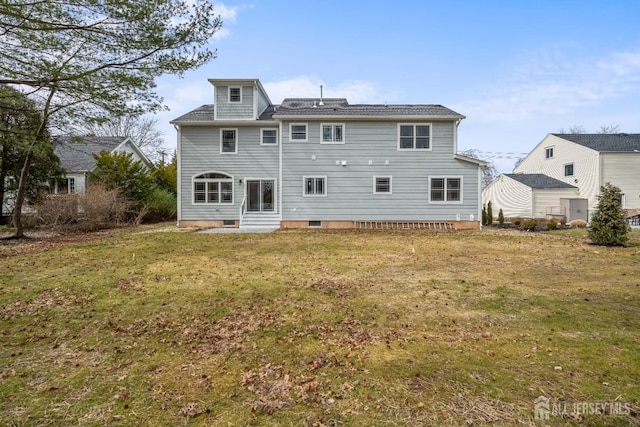 back of property with a lawn and entry steps