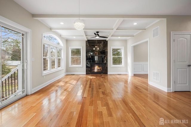 unfurnished living room featuring coffered ceiling, beamed ceiling, visible vents, and light wood-style flooring