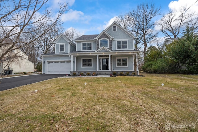 view of front of property featuring a front yard, a porch, a garage, and driveway