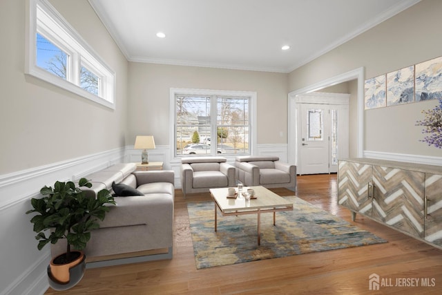 living area featuring a wealth of natural light, wainscoting, and wood finished floors